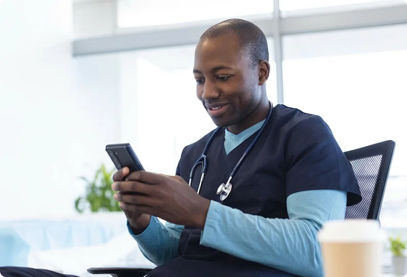 happy male nurse reading his smart phone