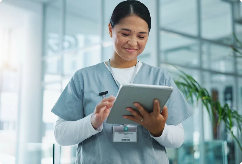 happy female nurse reading his tablet device